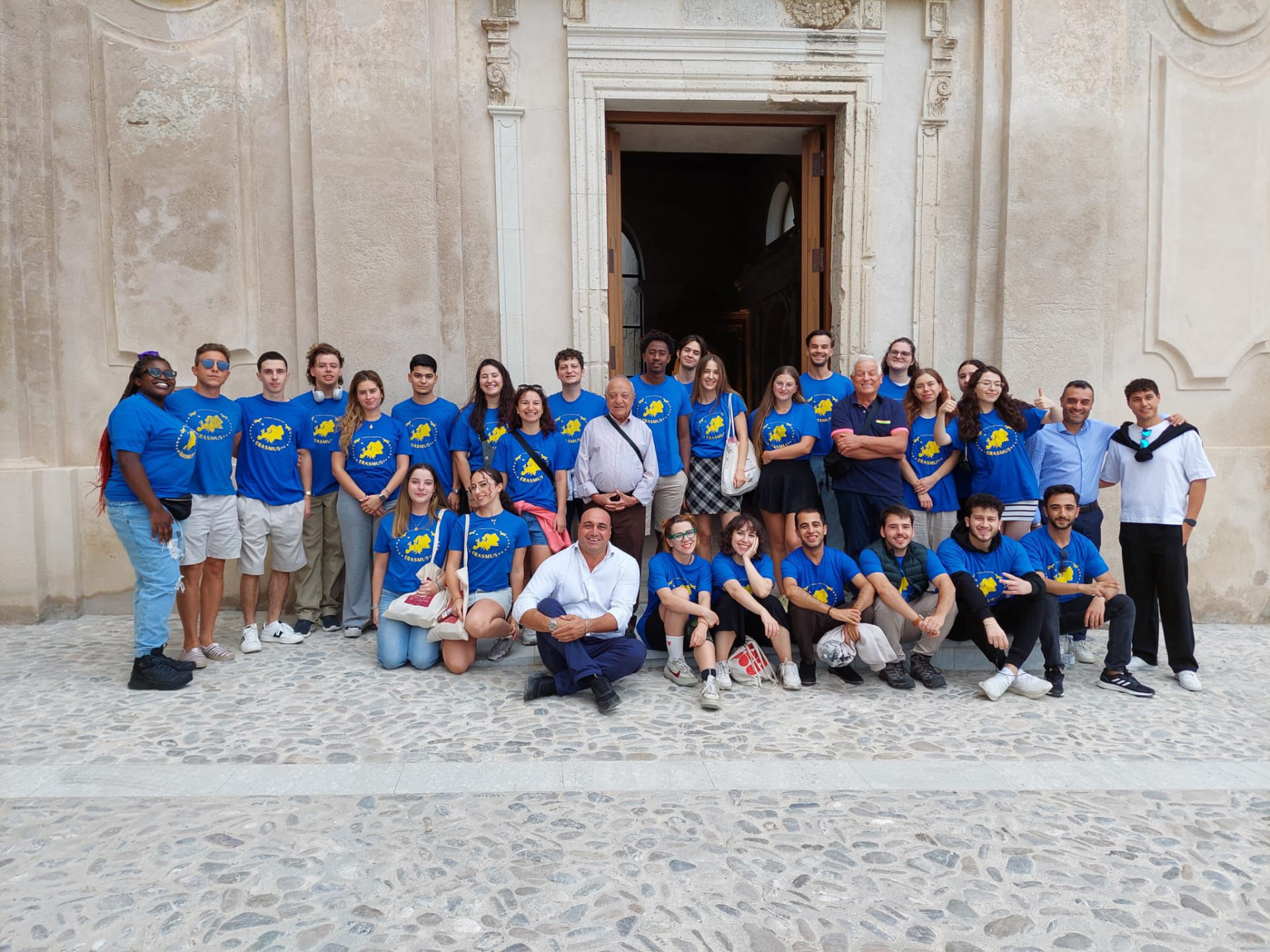 Partecipanti in maglietta blu davanti a una chiesa storica